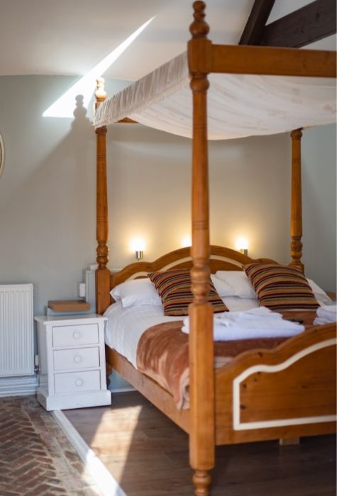 The Place To Stay, Knoll Hill Farm, Stylish Boutique Bed and Breakfast Guest House Accommodation For The Perfect Staycation & holiday ~ Room 5 (Oak Tree) En-Suite Superior Double Sleeps 2 ~ Room Size: 16 sqm. In an idyllic courtyard setting, this barn conversion guest suite is where your romantic break begins. This intimate superior double room with its four poster bed and spacious en-suite shower room retains many of the original barn features including a beamed ceiling and period wooden doors is an ideal hideaway. Part of the floor is mildly uneven due to an original feature of the herringbone brick floor, which adds to the quirkiness of this room. The Place To Stay, Knoll Hill Farm, Stylish Boutique Bed and Breakfast Guest House Accommodation For The Perfect Staycation & holiday ~ Room 5 (Oak Tree) En-Suite Superior Double Sleeps 2 ~ Room Size: 16 sqm. In an idyllic courtyard setting, this barn conversion guest suite is where your romantic break begins. This intimate superior double room with its four poster bed and spacious en-suite shower room retains many of the original barn features including a beamed ceiling and period wooden doors is an ideal hideaway. Part of the floor is mildly uneven due to an original feature of the herringbone brick floor, which adds to the quirkiness of this room.